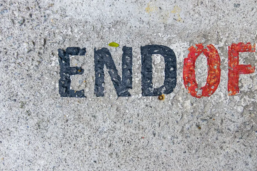 Auf grauen Beton gemalte Grossbuchstaben „END“ in Schwarz und „OF“ in Rot, die Farbe abgeplatzt, der Rest des Schriftzugs liegt ausserhalb des Bildes