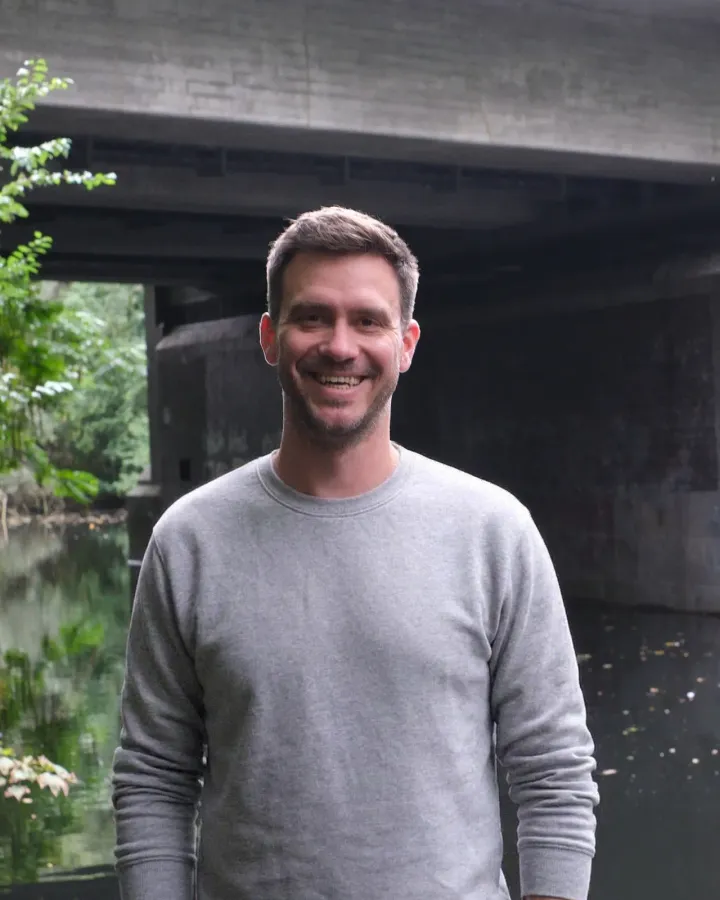 Philipp Kaiser, Mitgründer von ganzheit, an einem Kanal unter einer Brücke